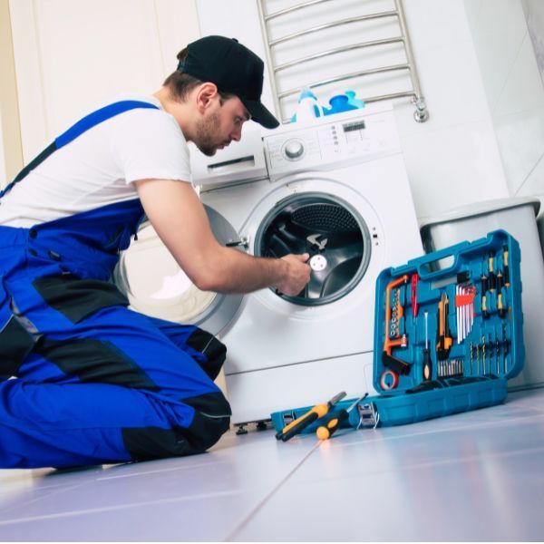 فني صيانة يفحص مجفف ملابس حراري باستخدام أجهزة تشخيص متقدمة في الدمام