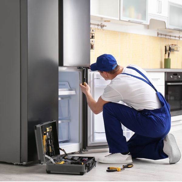 فني صيانة يفحص دائرة التبريد في ثلاجة منزلية باستخدام أجهزة قياس متقدمة بالدمام